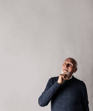 Yaşlı adam şüphe ve tereddütlerle dolu. Adam yukarı bakıyor..