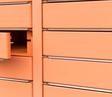 Posta kutusu, kapı açık. Kiralık turuncu posta kutusu. Alıcının oradan alabileceği paketler için posta kutusu dolapları.