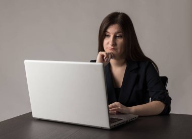 Mavili genç kadın internete bakmak için dizüstü bilgisayar kullanıyor..