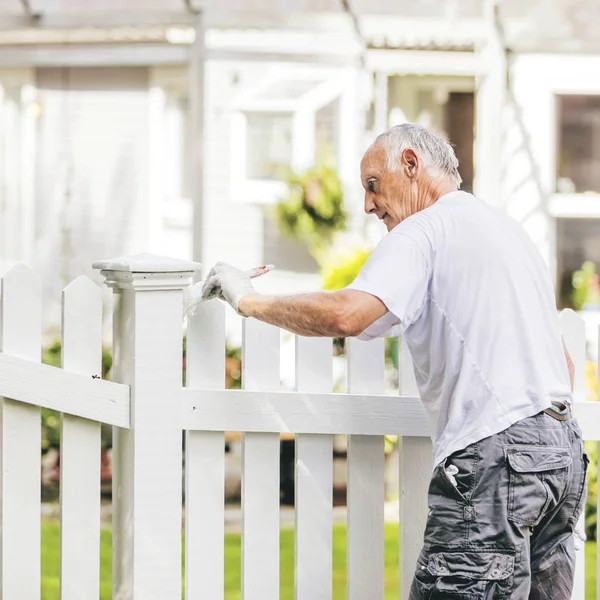 Active Senior Man Painting White Picket Fence Warm Toning — Stock Photo, Image