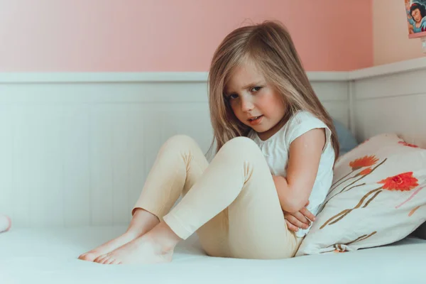 Lilla flickan i sängen har en magont — Stockfoto