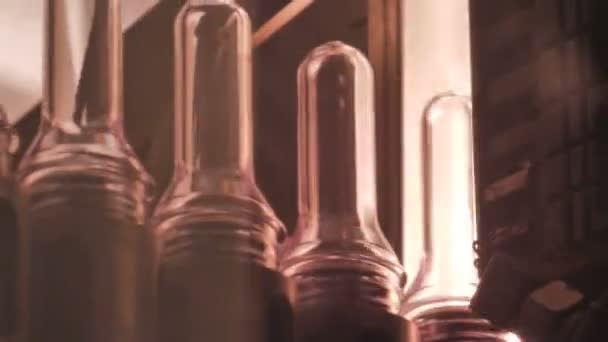 Las botellas de preforma de plástico se mueven a través de la máquina para soplar — Vídeos de Stock
