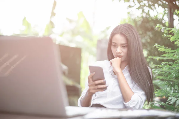 美丽的女孩坐在咖啡馆里手持智能手机 — 图库照片