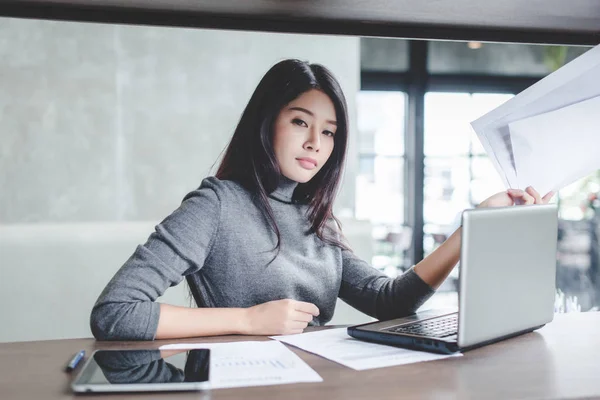 Onun iş istasyonu dizüstü bilgisayarda çalışan genç iş kadını.