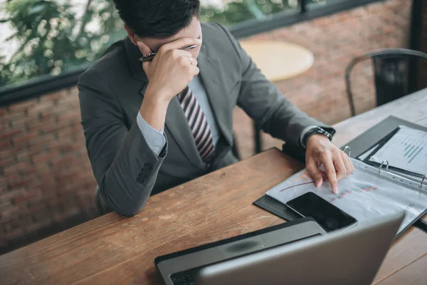 Bitkin hissediyorum. Hüsrana uğramış genç sakallı adam ofisteki iş yerinde otururken burnuna masaj yapıyor ve gözlerini kapalı tutuyor.