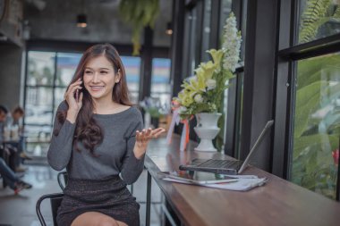 Genç Asyalı kadın ofiste dizüstü bilgisayar ile çalışma