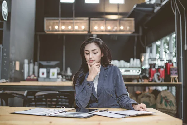 Young attractive Asian business woman sleeping, drowsing or taking a nap at her desk, Tired business woman accountant with bills and paper folders in office, tired young business woman with laptop.