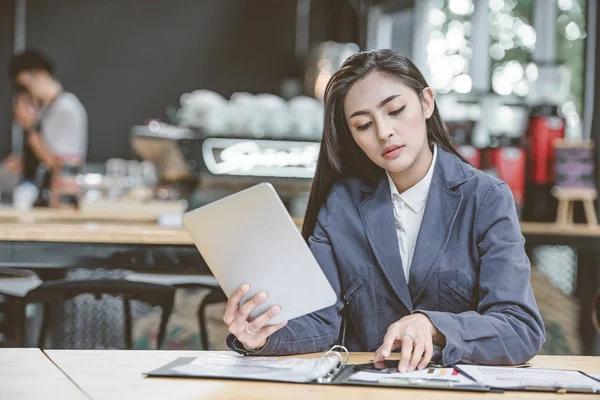 年轻有魅力的女人打电话给她的银行服务咨询最后的交易 同时正在使用在线银行在笔记本电脑上 有智能手机会话的女性商务人士 — 图库照片