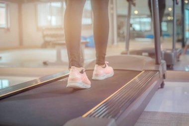 Bir spor salonunda bir koşu bandı üzerinde çalışan kadınlar üzerinde ayakkabı, yakın çekim. egzersiz kavramı. Fitness ve sağlıklı yaşam tarzı