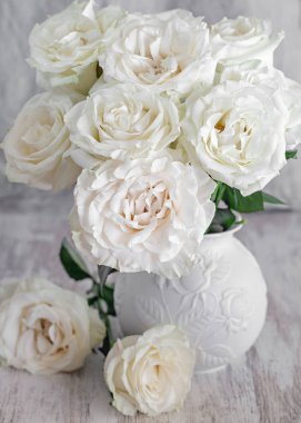 Bir tabloda bir vazoda güzel taze gül. açık renkli