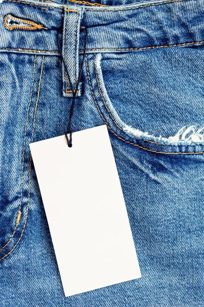 Blue denim fabric with a pocket and label as a background.