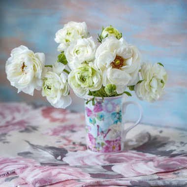 Beyaz ranunculus. Masadaki vazoda duran bir demet bahar çiçeği. Çok güzel çiçekler. Pastel tonlama..