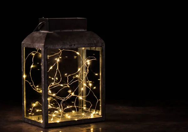 fairy lights inside vintage lantern on wooden table