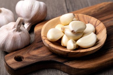 Garlic Cloves and Bulb in vintage wooden bowl clipart