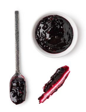 Beyaz arka planda küçük cam kase ve bir kaşık kırmızı frenk üzümü reçeli.