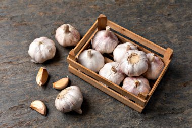 Sarımsak karanfil ve soğan eski ahşap masada.