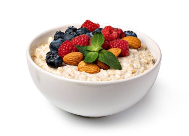 Beyaz arka planda yulaf ezmesi ve fındık.