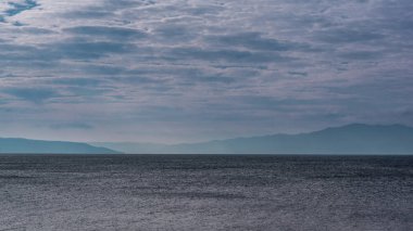 Mavi gökyüzü bulutlu ve Pütürlü yüzeyi (küçük dalgalar) ile deniz manzaralı... Arka plan için kullanın.