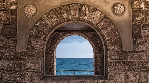 Taş duvardaki mavi deniz ve gökyüzü beyaz bulutlar ile seyir doğal görünümü penceresinden. Opatija, Hırvatistan, Europe.