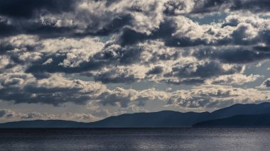 Karanlık gökyüzü ve fırtına öncesi sessizlik deniz manzaralı. Mavi döküm.