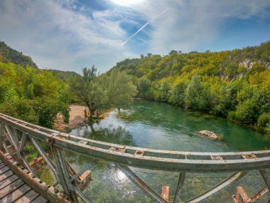 Eski metal köprüden Cetina nehrinin manzarası. Bir grup turist rafting macerasına hazırlanıyor. Cetina 'da Blato, Hırvatistan' da Sonbahar.