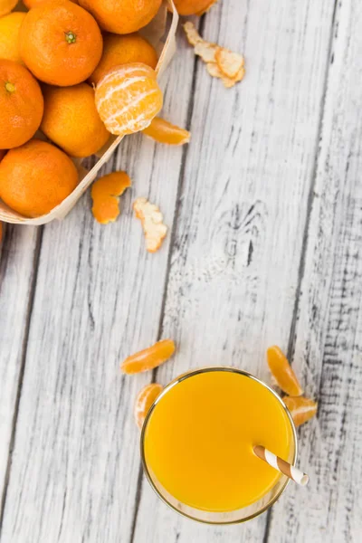 Wooden table with fresh made Tangerine Juice (close-up shot) — Stock Photo, Image