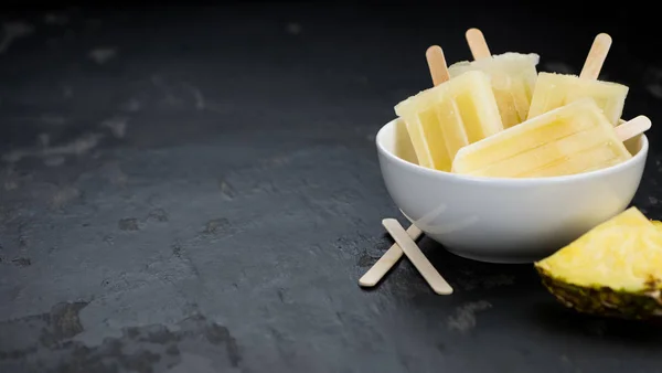 Ananas Eis am Stiel auf einer Schieferplatte (selektiver Fokus) — Stockfoto