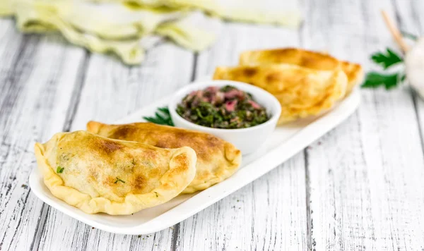 Ξύλινο τραπέζι με empanadas (λεπτομερή κοντινό πλάνο, επιλεκτική f — Φωτογραφία Αρχείου