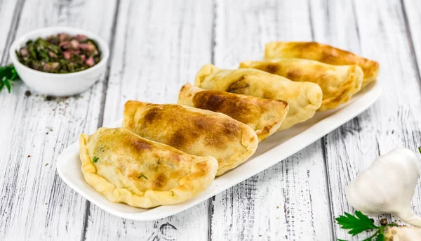 Sommige empanadas op een Vintage houten tafel (selectieve focus; close — Stockfoto