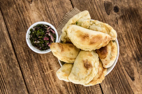 Ξύλινο τραπέζι με empanadas (λεπτομερή κοντινό πλάνο, επιλεκτική f — Φωτογραφία Αρχείου