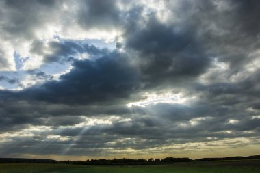 Karanlık yağmurlu bulutlar ve gökyüzü güneş ışığı