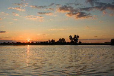 Günbatımı ve bulutlar göl kenarında