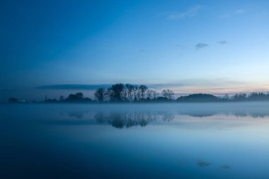 Sis göl günbatımı ve ağaçlar sahilde sonra