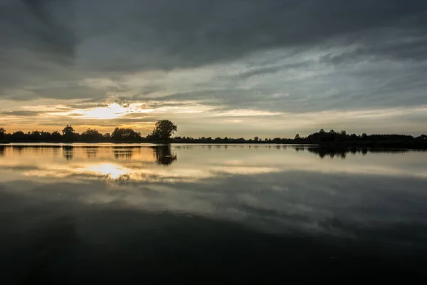 Nubes Oscuras Durante Puesta Del Sol Sobre Lago Tranquilo — Foto de Stock