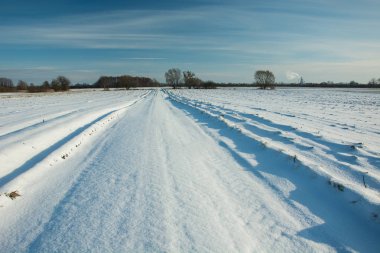 Yol ve kar, ufuk ve mavi gökyüzü - ile kaplı alanlar görünümü bir güneşli kış gününde