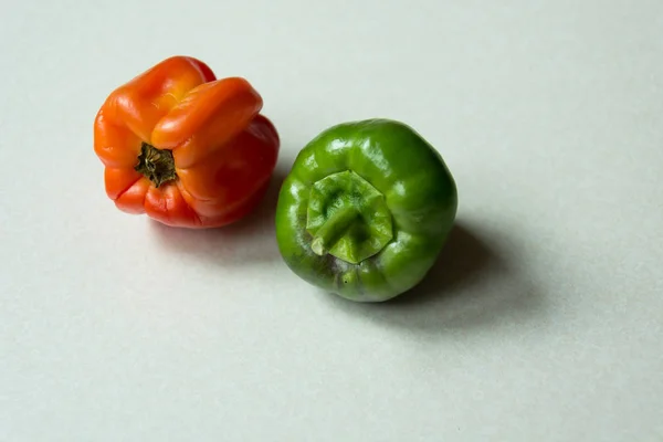 Dos Pimientos Una Encimera Brillante Naranja Verde Primer Plano — Foto de Stock