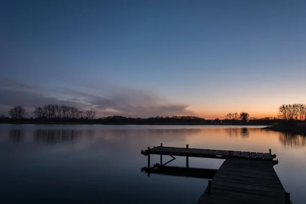 Cais no lago e céu colorido após o pôr do sol — Fotografia de Stock
