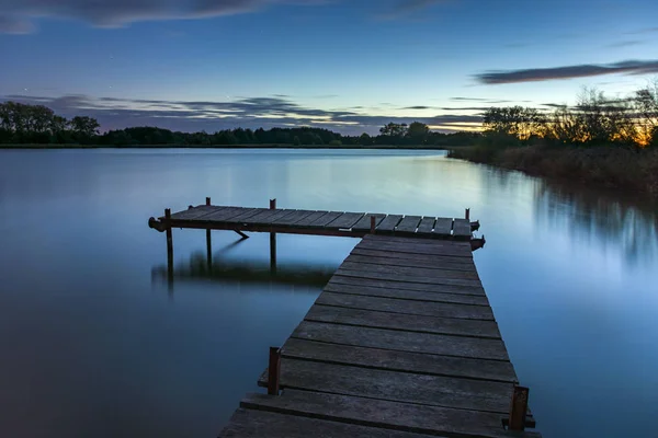 Kleine brug over het water na zonsondergang, lange belichtingstijd — Stockfoto