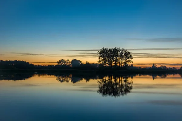 Céu noturno e árvores refletindo na água — Fotografia de Stock