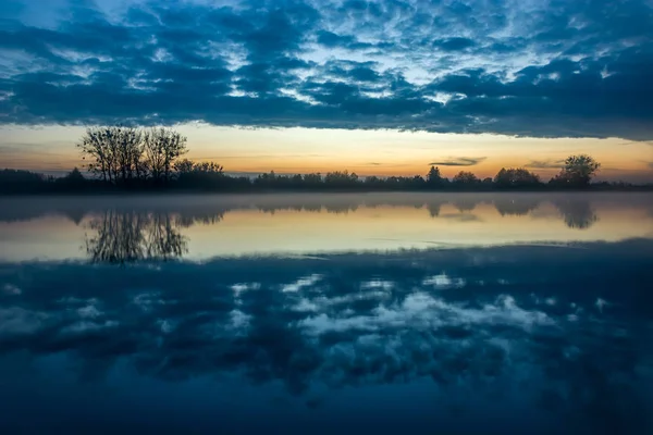 Evening fog over the lake and reflection of clouds in the water — Stock Photo, Image