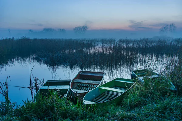 Boote am Ufer, Schilf und nebliger See — Stockfoto