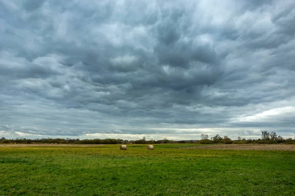 Nuvens chuvosas escuras sobre o prado — Fotografia de Stock