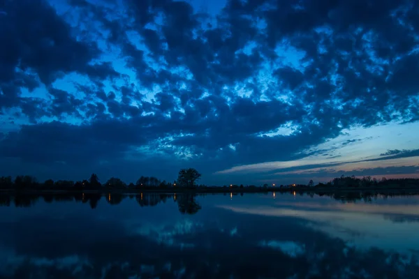 Nubes oscuras en el cielo de la tarde reflejándose en el lago — Foto de Stock