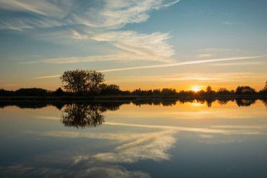 Gölde gün batımı ve sudaki bulutların yansıması, Ekim akşamı.