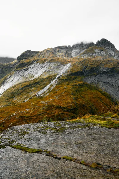 从挪威洛福敦群岛山脉的悬崖边可以看到一个有瀑布和湖泊的山谷 该地点位于挪威北部山区索尔瓦根附近 九月是一个明亮 阴冷的日子 — 图库照片