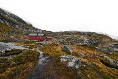 Norveç 'teki Lofoten 'deki dağlarda bulunan uzak kırmızı ahşap kabine giden yürüyüş parkuru. Kabin Munken (Moskenesoy) Dağı 'nda yer almaktadır ve Munkebu denir. Peyzaj kayalar, taşlar ve portakal çim ve yosun oluşur.