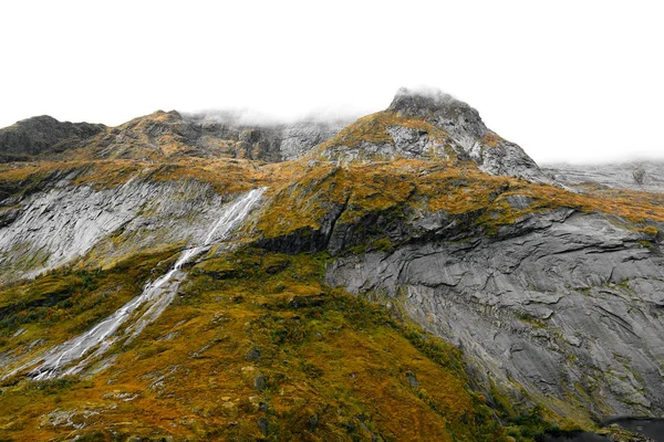 Norveç 'teki Lofoten 'deki dağ zirvesinden bir vadiye akan bir şelalenin panoramik görünümü. dağlar, çim ve yosun ile kaplıdır. Onlar vadi içine yol açan dik bir eğim var.