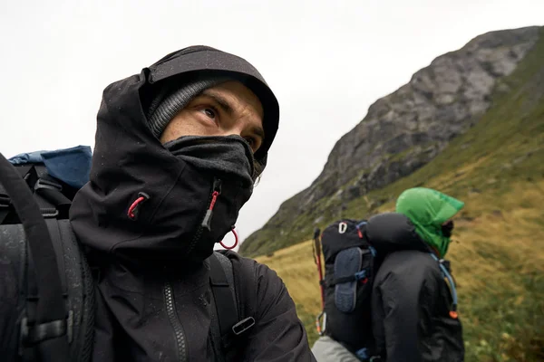 Norveç'te Lofoten Adaları'nda sırt çantasıyla yürüyüş olan iki genç adamın başı ve üst bedeni. Yüzleri bir başlıkla kaplı..