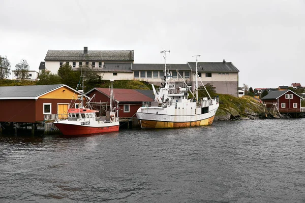 Norveç'te Lofoten Adaları geleneksel ahşap balıkçı kabinleri önünde Reine limanında iki küçük tekneler.