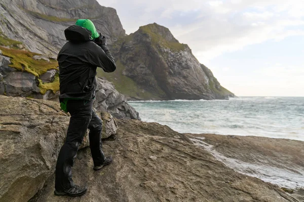 Genç fotoğrafçı Bunes Sahili 'ndeki dağlarda duruyor Norveç' teki Lofoten Adaları 'ndaki manzaraları fotoğraflıyor..